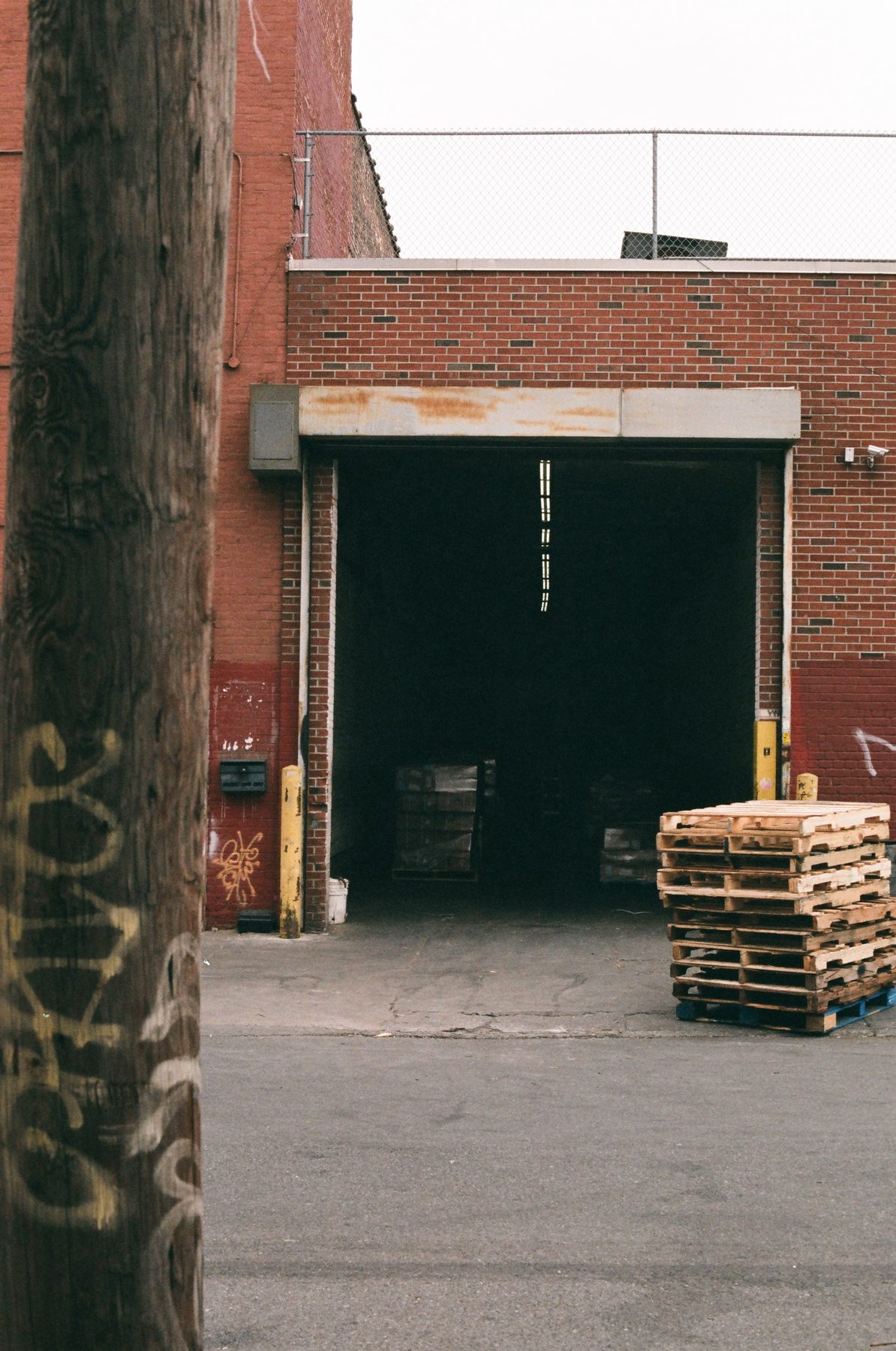 An open loading dock with stacked pallets at a brick industrial unit